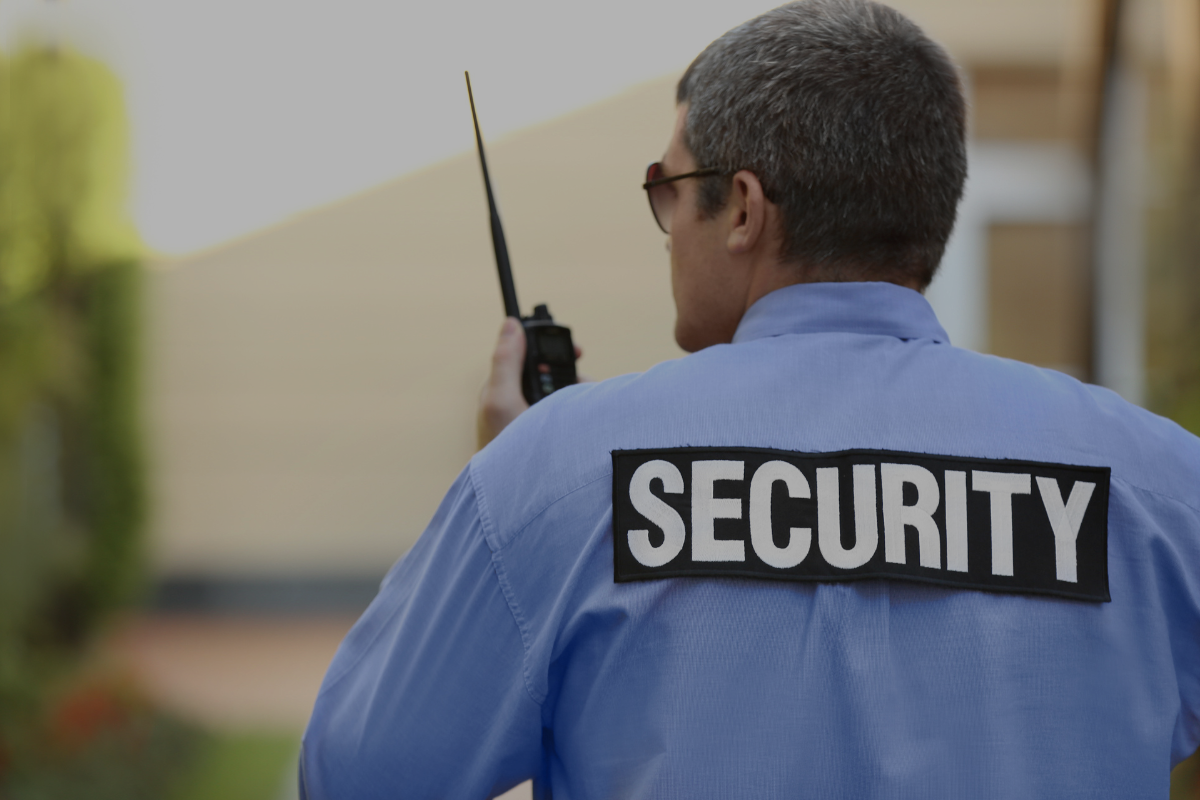 Security guard with walkie talkie providing mobile security patrol and armed guard services.